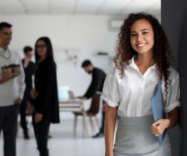 Young African-American woman with clipboard in office